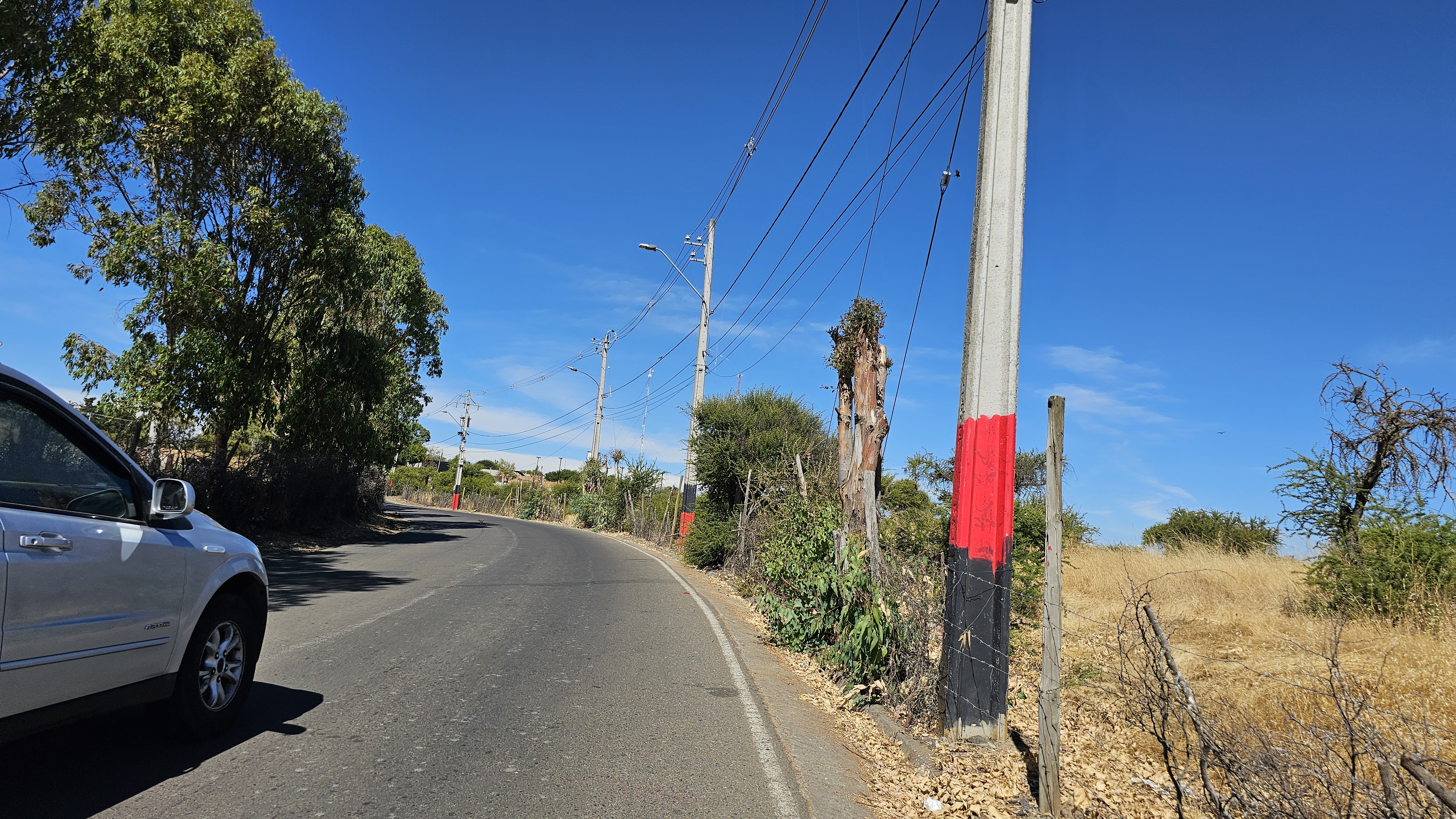 Fotografía de la carretera asfaltada con un automóvil transitando